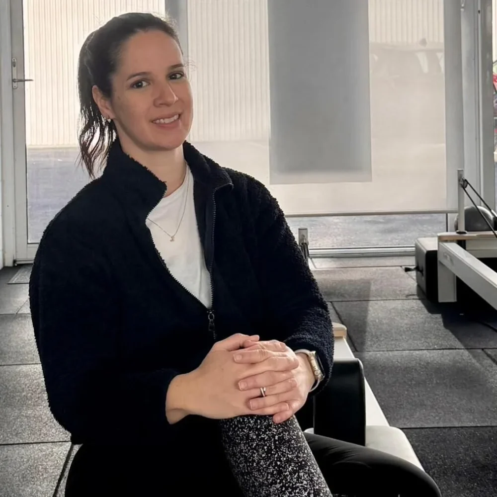 Pilates instructor in a reformer Pilates studio.